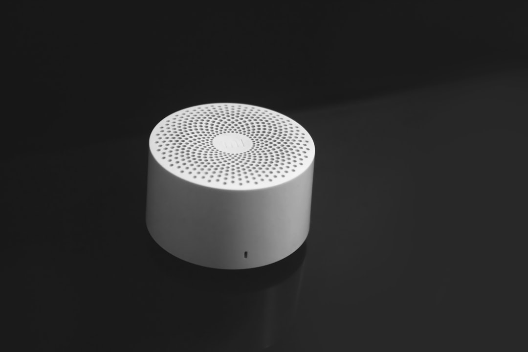 programs-02 a-white-speaker-sitting-on-top-of-a-black-table-qtsrvfthvpa