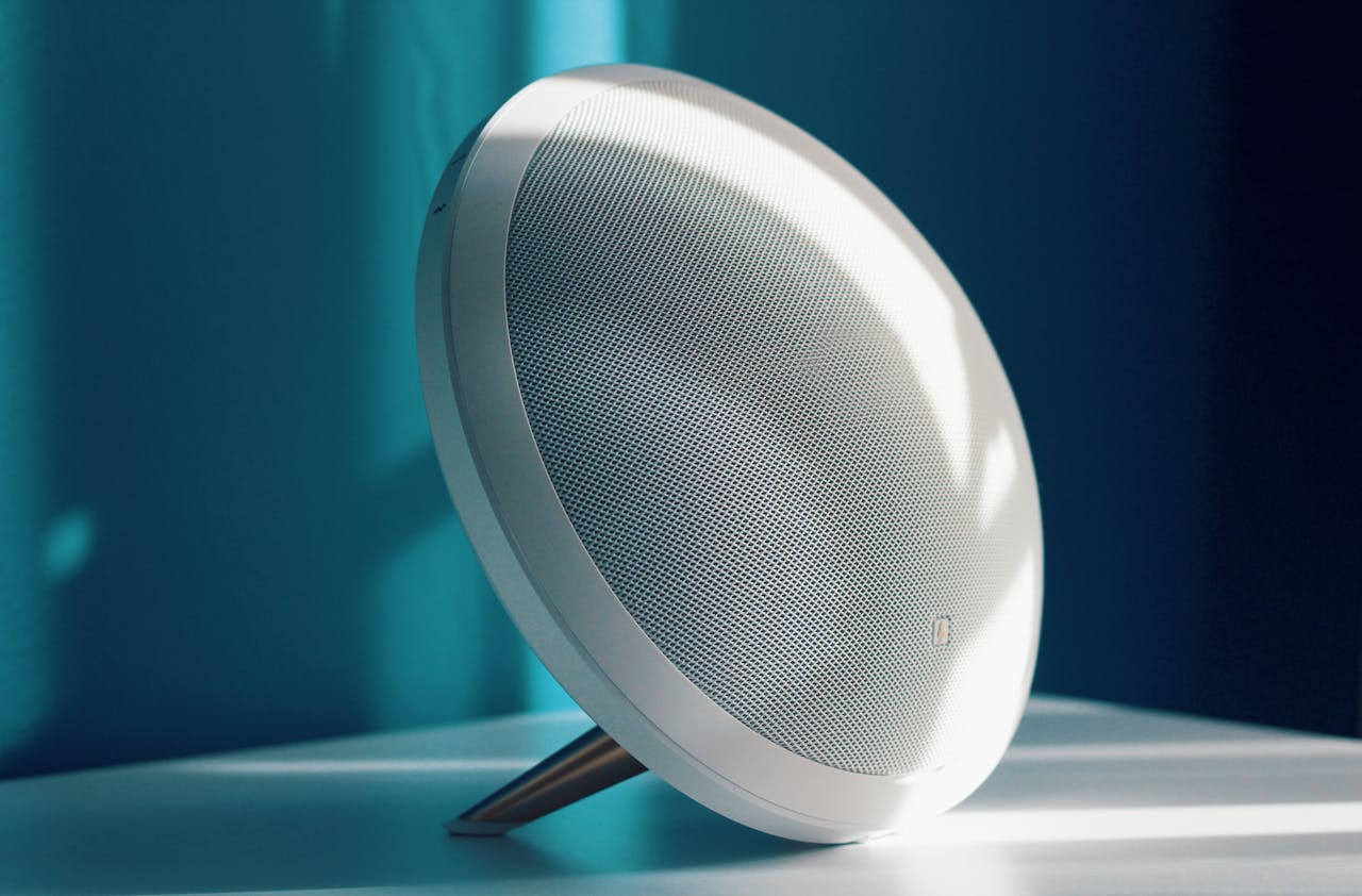 gallery-img-04 Close-up of a modern wireless speaker with a minimalist design, lit by natural light indoors. Ideal for tech product showcase.